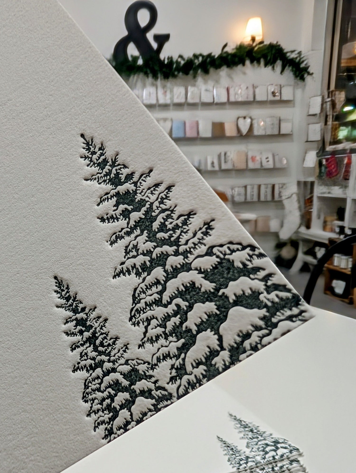 Stack of greeting cards with snowy tree design in a store setting