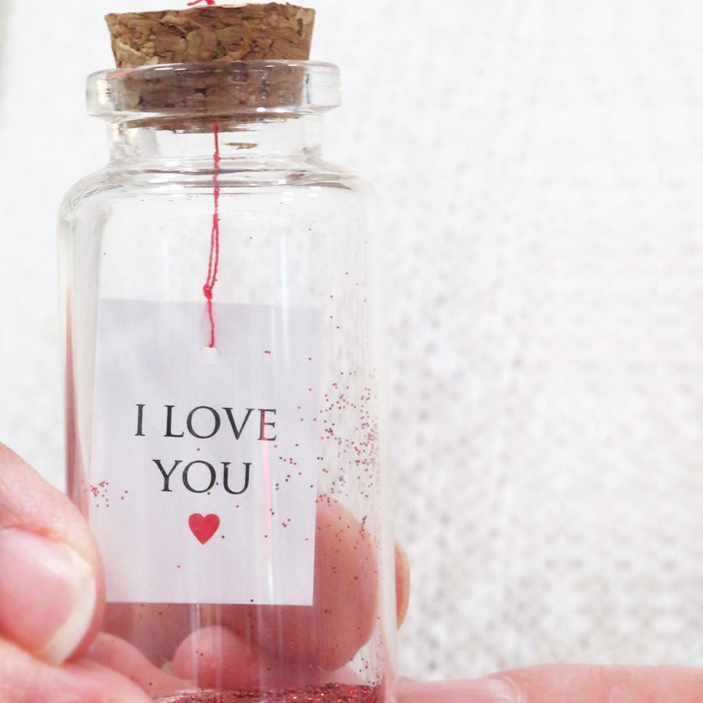 Petit message « Je t'aime » dans une bouteille avec un cœur en laine feutrée